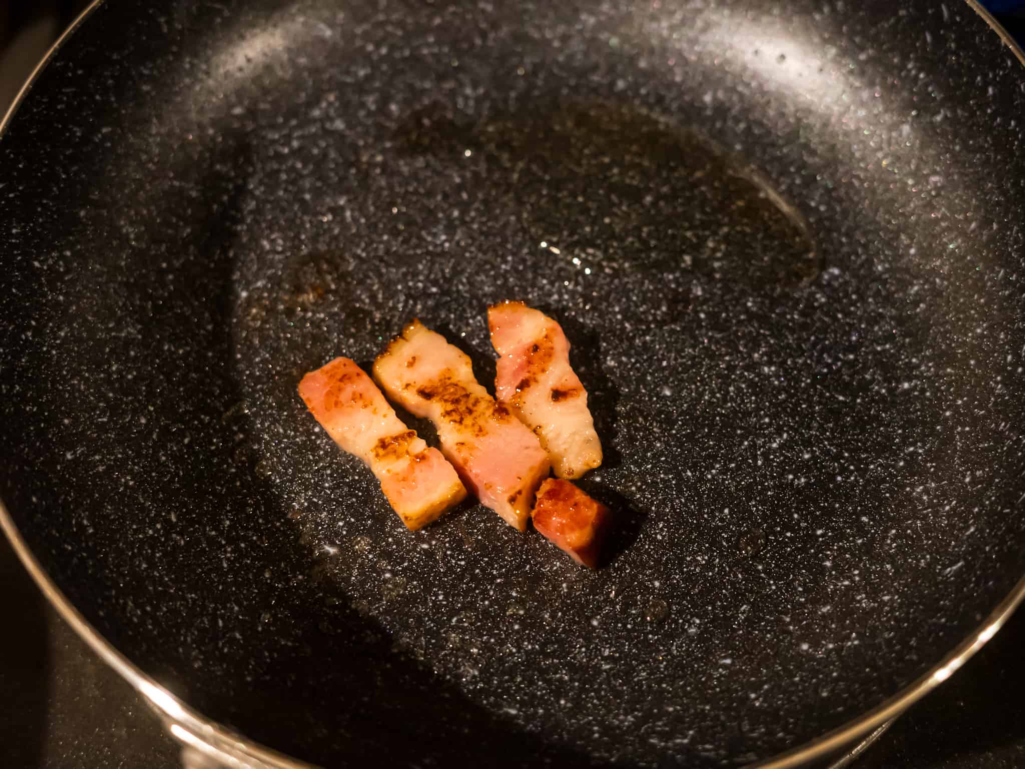 新しいフライパンでベーコンを焼く